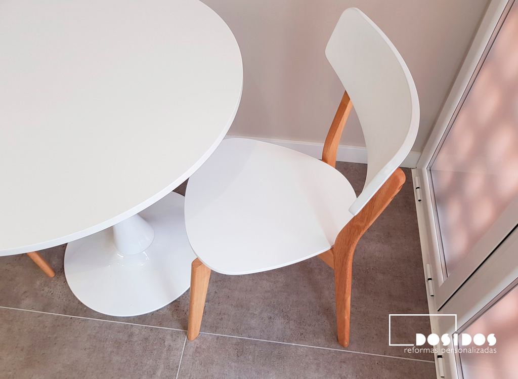 Mesa redonda y sillas de diseño para office de cocina blanca.
