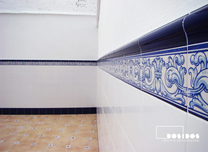 Detalle de la zocalada de azulejo Valenciano, blanco con cenefa dibujos azules. Colocada a media altura en una terraza.