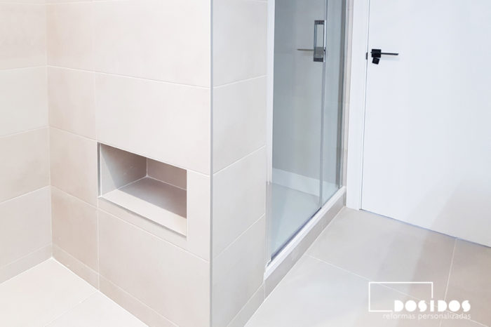 Reforma del cuarto de baño, detalle del box ducha con mampara de cristal abatible con fijo, hueco decorativo hornacina