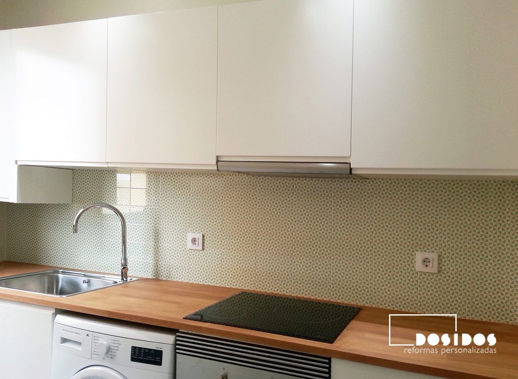 reforma de cocina pequeña, muebles blancos, encimera de madera y azulejos verdes molinillo.
