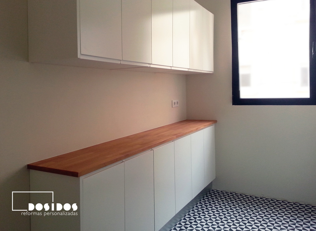 Mueble de cocina blanco con encimera de madera. Suelo vintage azulejos negros y blancos
