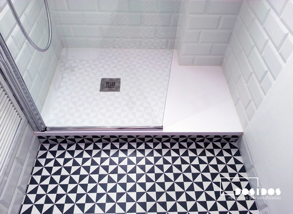 Plato de ducha con el suelo en azulejos blancos y negros dibujo triángulos.