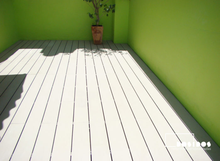 Terraza con suelo técnico y parades pintadas en verde.