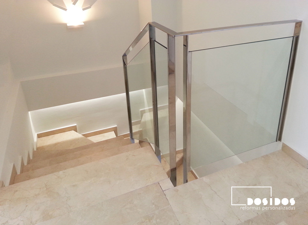 Barandilla de escalera fabricada en pletina de acero inoxidable y cristal transparente.