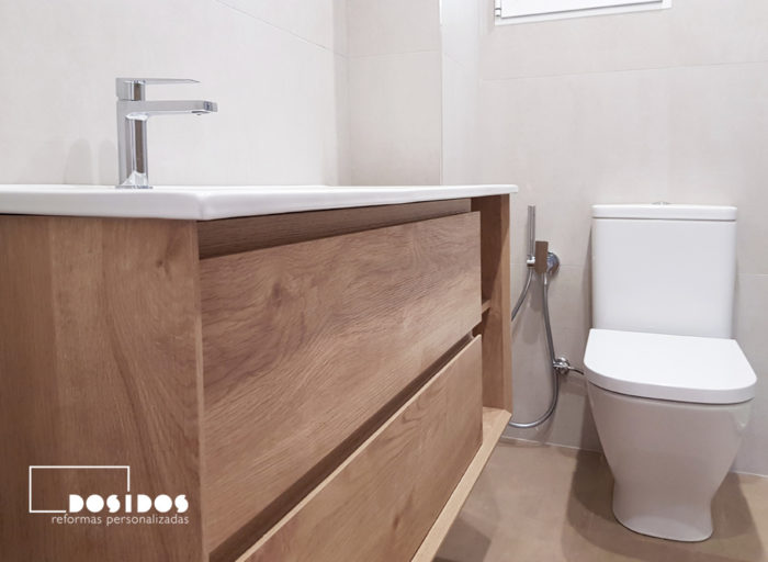 Reforma de un baño detalle del mueble de madera con uñero e inodoro con grifo de bidé wc
