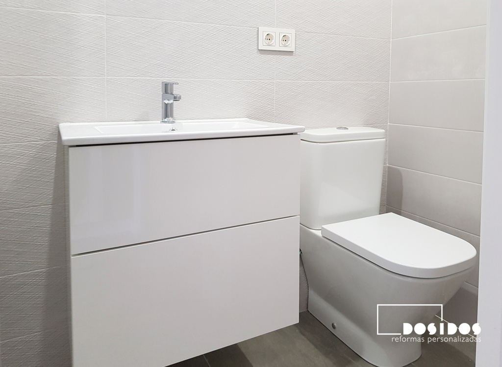 Mueble blanco con lavabo de porcelana fondo reducido e inodoro compacto para un baño pequeño