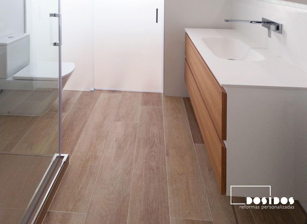 Reforma de baño moderno, blanco con suelo imitación a madera, mueble de baño con 2 cajones.